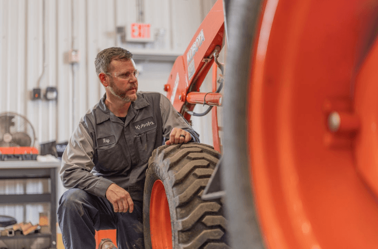 Kubota technician working on tractor