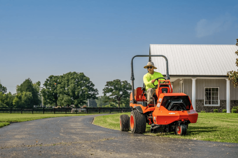 Man using blower attachment on front mount mower