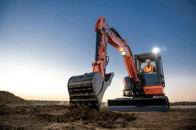 Man operating excavator at night